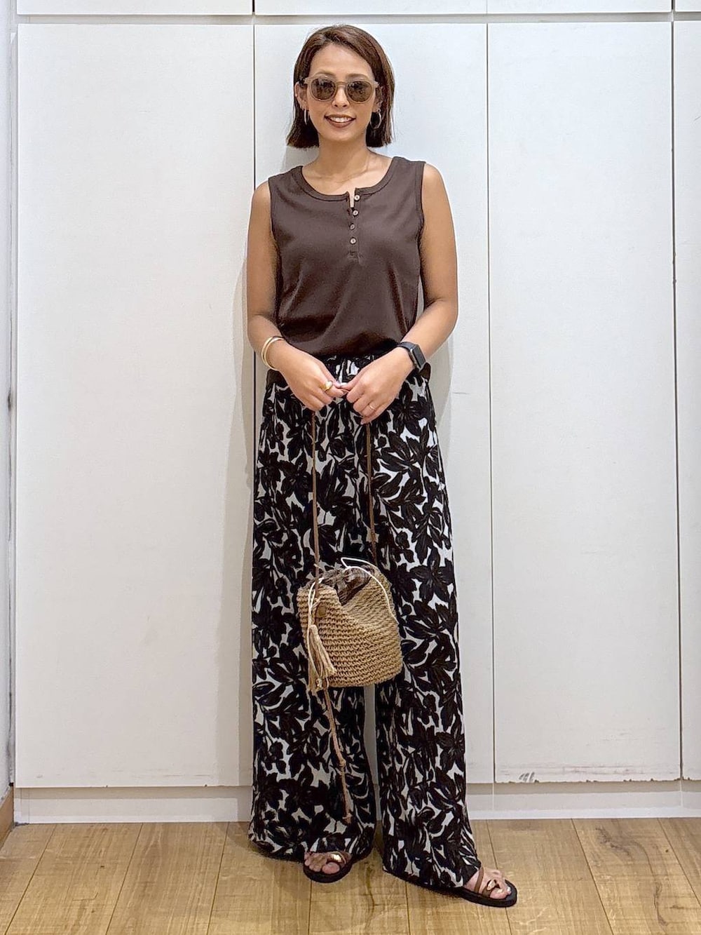 ベージュ系のその他パンツ、ホワイト系のタンクトップ、ベージュ系のショルダーバッグを着用したレディースの夏コーディネートの3枚目の写真