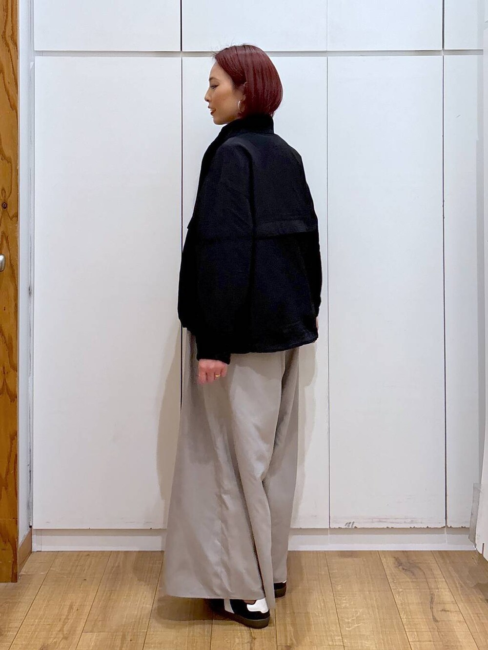 ブラック系のスニーカー、ブラック系のブルゾン、ブラック系のタンクトップを着用したレディースの春コーディネートの4枚目の写真