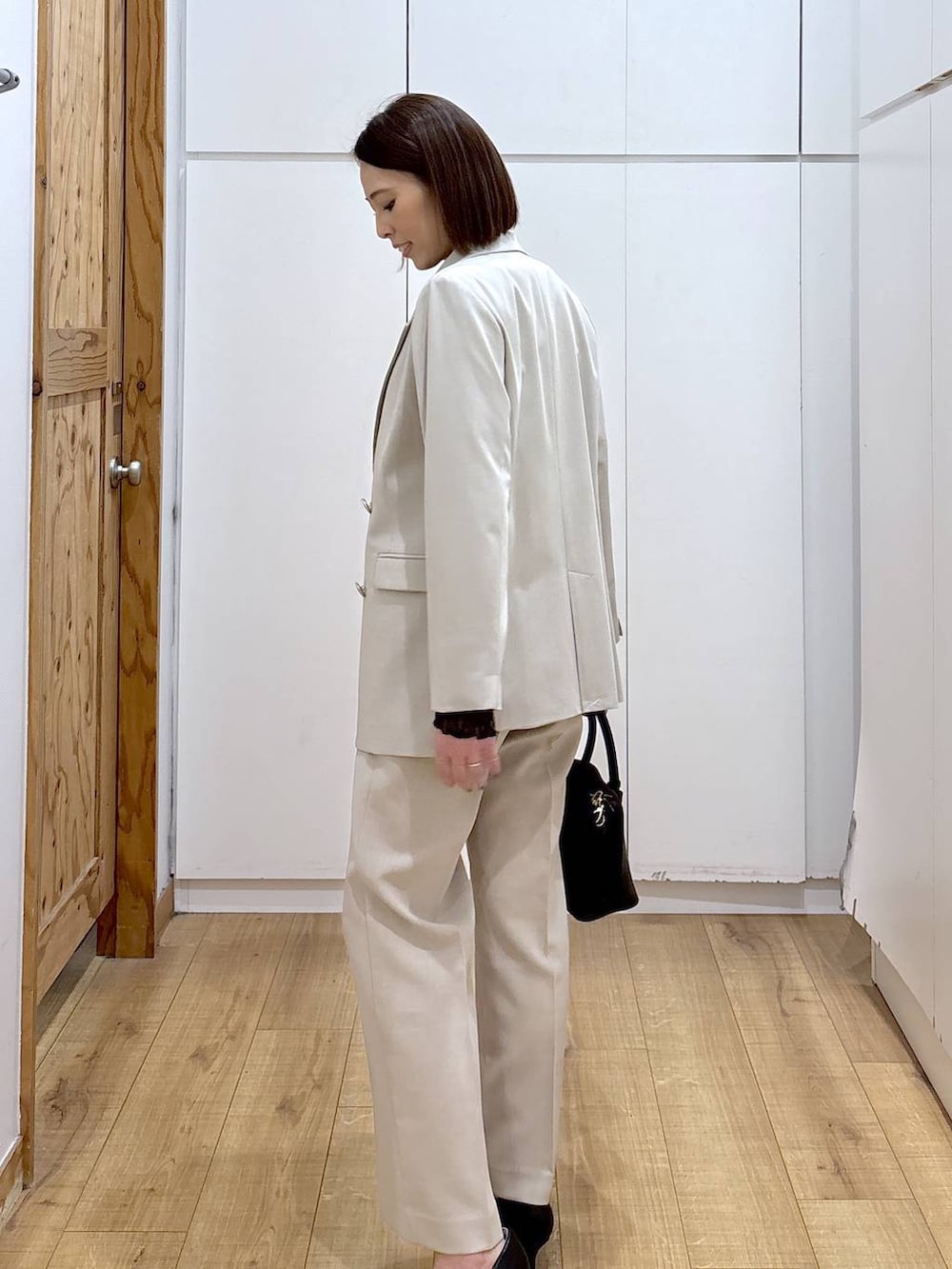 ブラック系のショルダーバッグ、ブラック系のパンプス、ブラック系のTシャツ/カットソーを着用したレディースの冬コーディネートの7枚目の写真