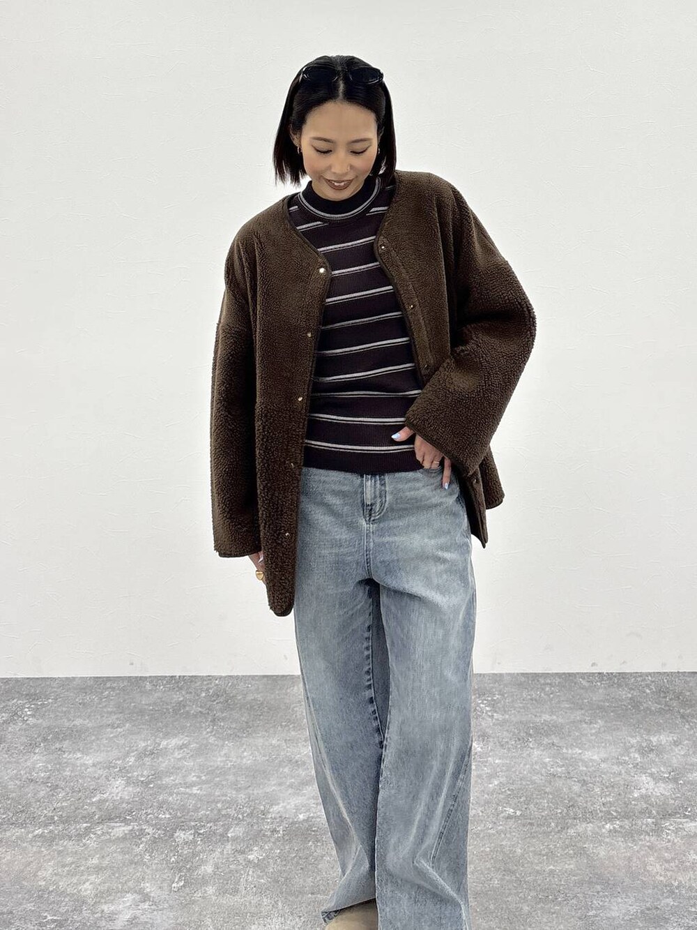 ホワイト系のニット/セーター、ブルー系のデニムパンツ、ブラウン系のノーカラージャケットを着用したレディースの冬コーディネートの8枚目の写真