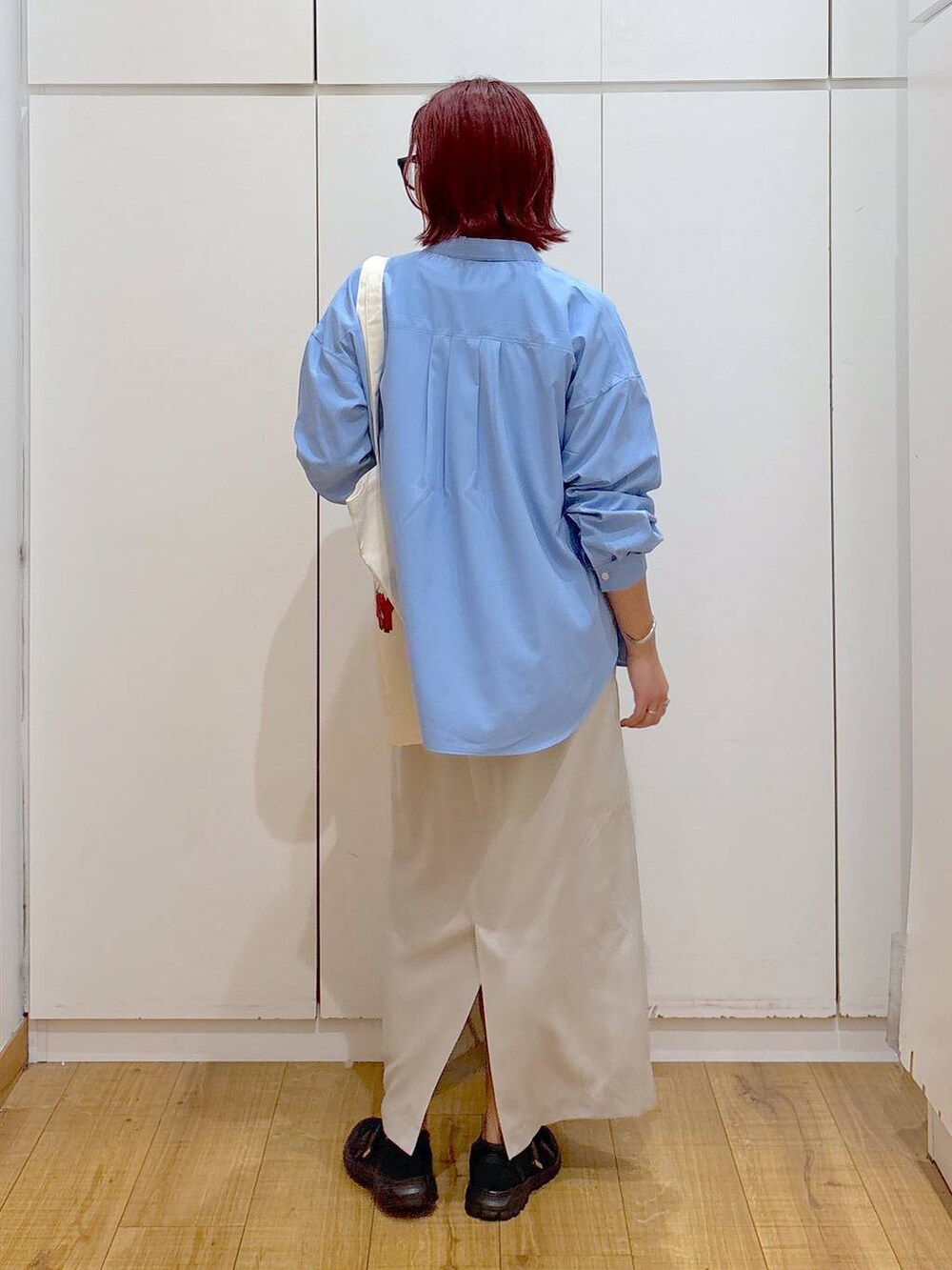 ブラック系のスニーカー、ホワイト系のTシャツ/カットソー、ブルー系のシャツ/ブラウスを着用したレディースの春コーディネートの6枚目の写真