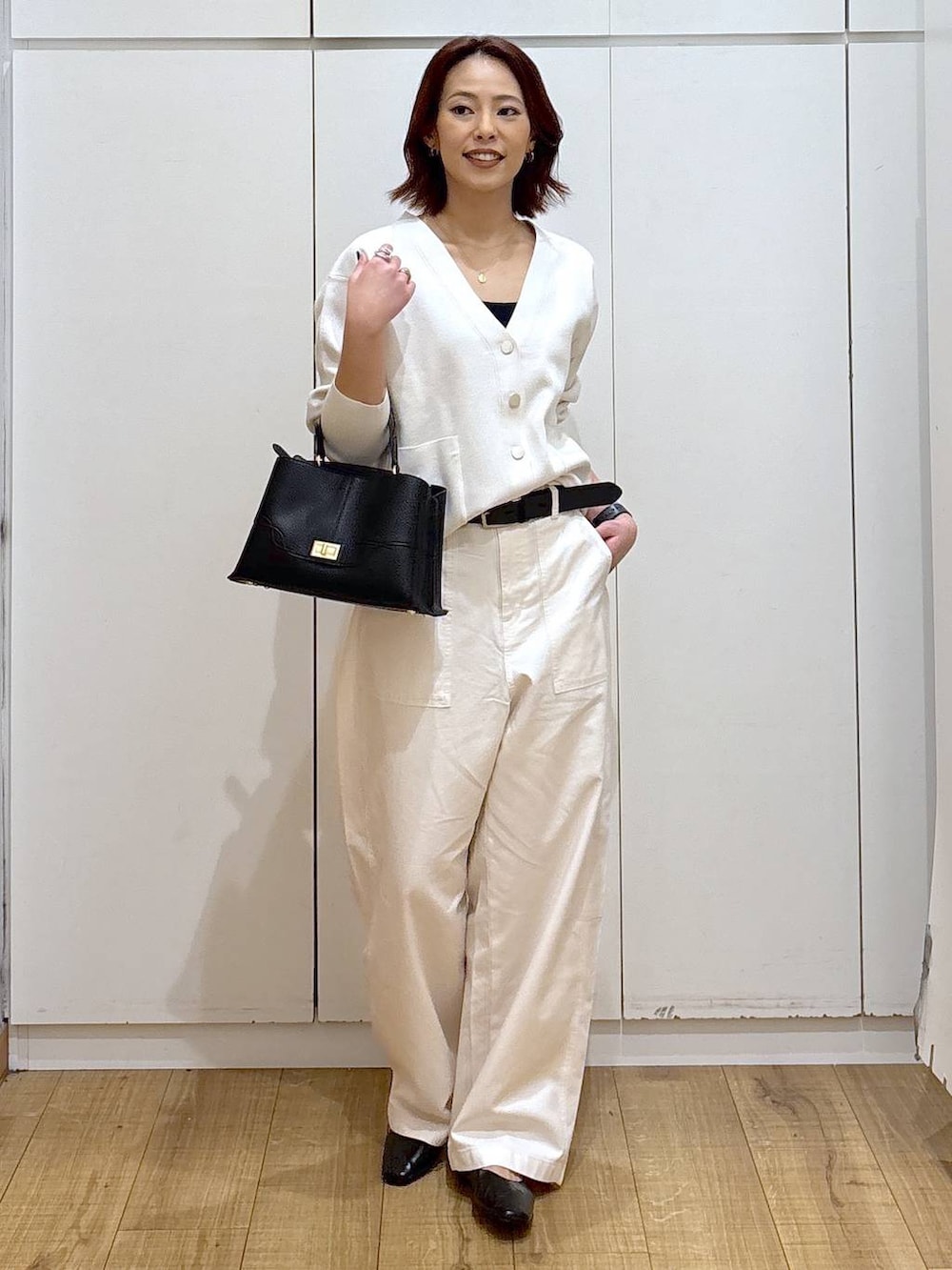 ブラック系のパンプス、ベージュ系のカーディガン/ボレロ、ブラック系のショルダーバッグを着用したレディースの春コーディネートの2枚目の写真