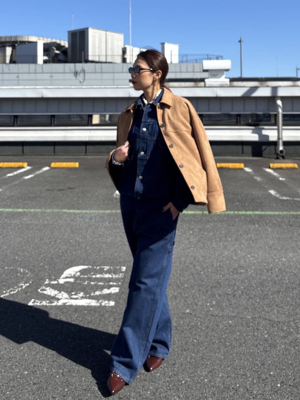 ブルー系のデニムジャケット、ブラウン系のテーラードジャケット、ブルー系のデニムパンツを着用したレディースの冬コーディネートの2枚目の写真