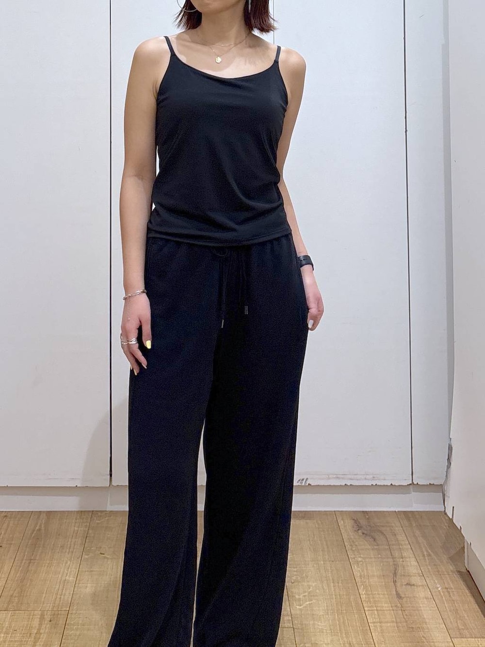 ブラック系のキャミソール、ブラック系のスウェットパンツ、ゴールド系のネックレスを着用したレディースの春コーディネートの2枚目の写真