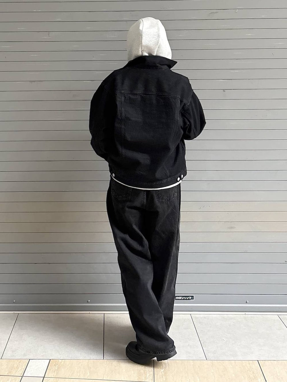 ブラック系のデニムパンツ、ブラック系のデニムジャケット、グレー系のパーカーを着用したレディースの冬コーディネートの7枚目の写真