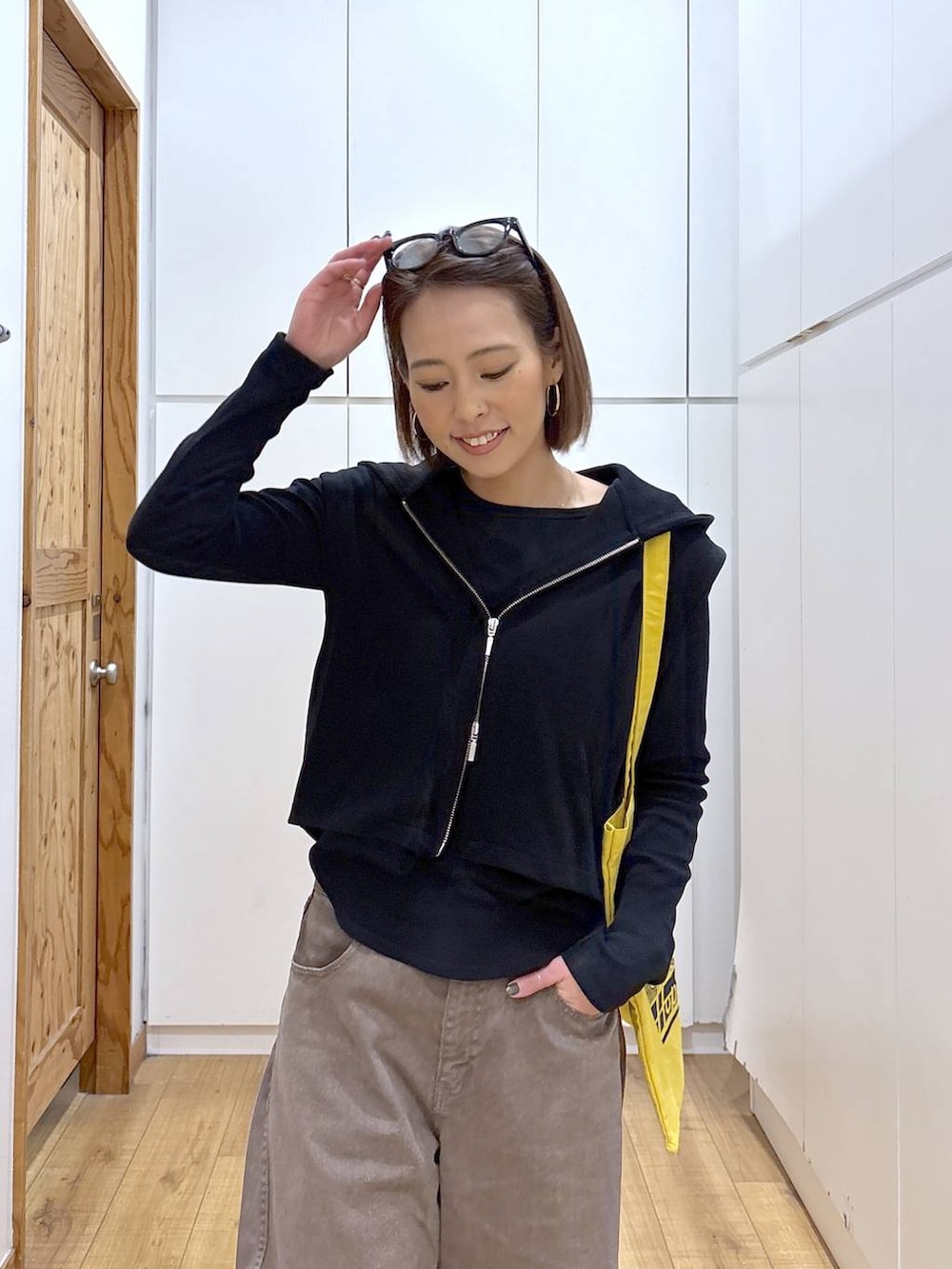 ブラウン系のデニムパンツ、イエロー系のトートバッグ、ブラック系のTシャツ/カットソーを着用したレディースの冬コーディネートの7枚目の写真