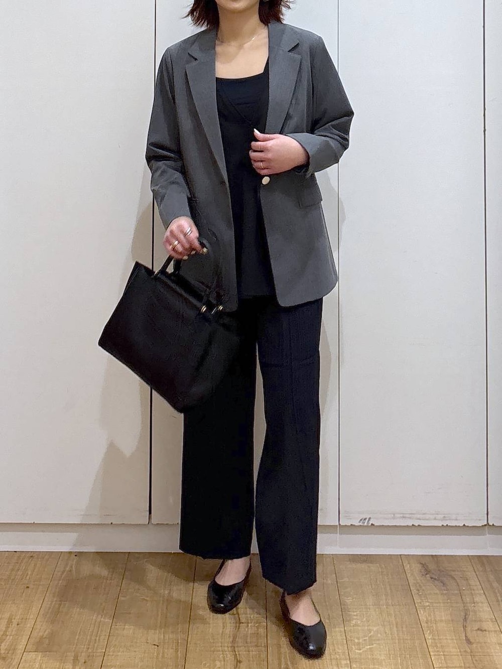 ブラック系のパンプス、ブラック系のセットアップ、ブラック系のトートバッグを着用したレディースの春コーディネートの3枚目の写真