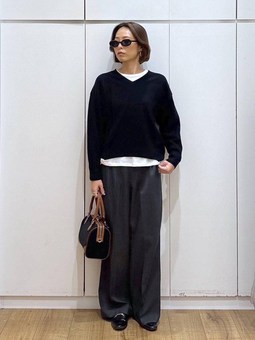 ブラック系のローファー、ブラック系のスウェット、グレー系のその他パンツを着用したレディースの秋コーディネートの6枚目の写真