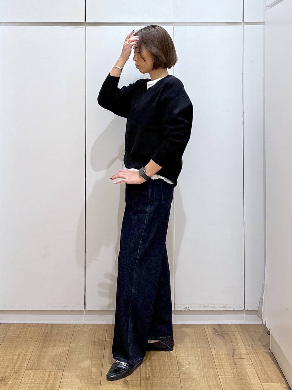 ブラック系のローファー、ブルー系のデニムパンツ、ブラック系のスウェットを着用したレディースの秋コーディネートの3枚目の写真