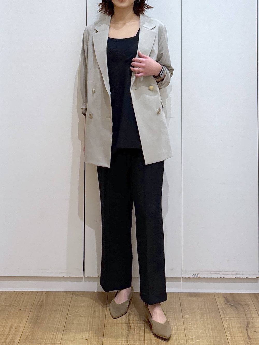 ベージュ系のパンプス、ベージュ系のテーラードジャケット、ブラック系のセットアップを着用したレディースの春コーディネートの4枚目の写真