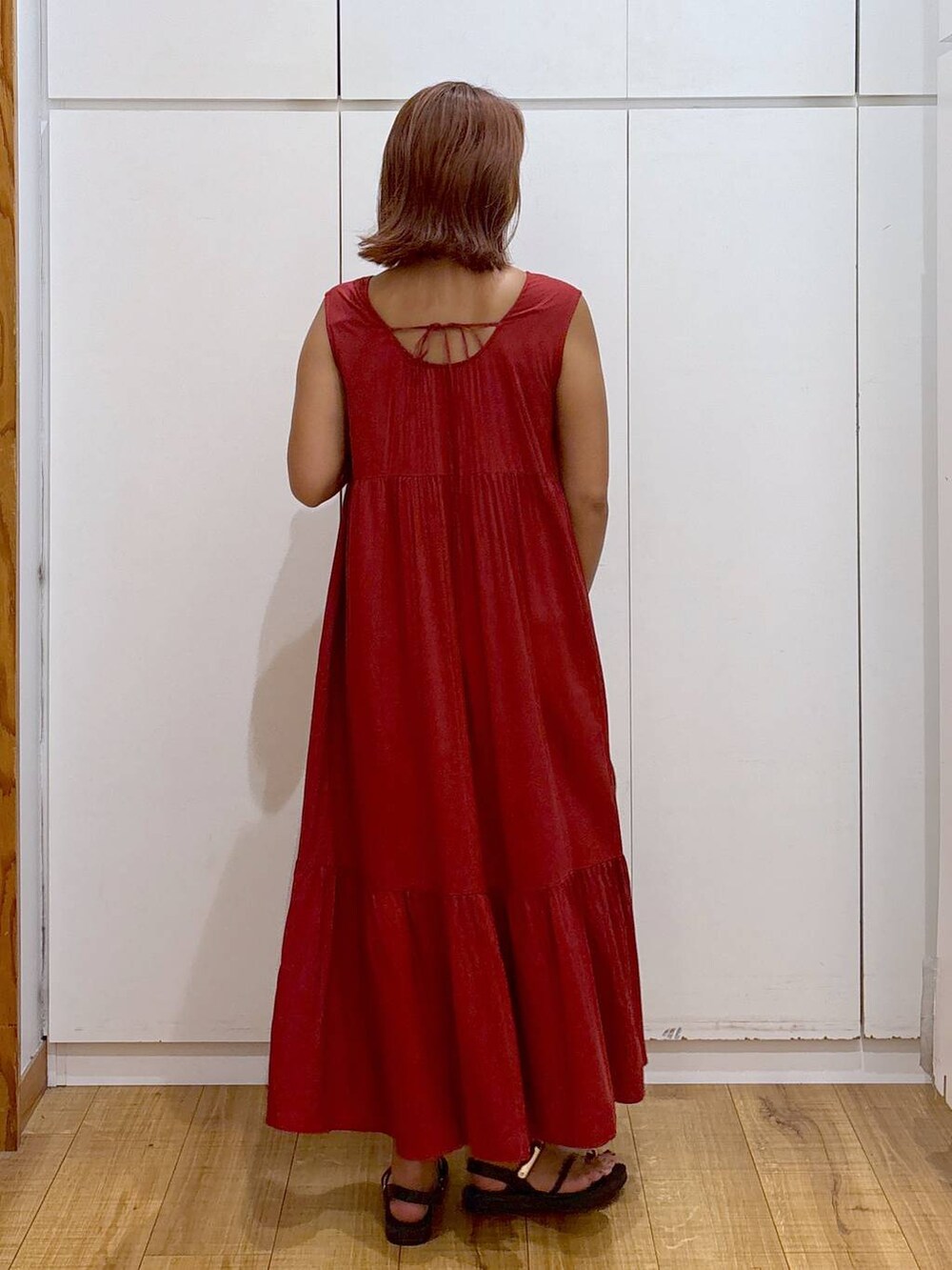 ホワイト系のショルダーバッグ、ブラック系のサンダル、レッド系のワンピースを着用したレディースの夏コーディネートの5枚目の写真