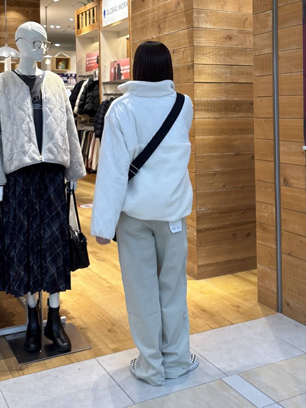 ホワイト系のブルゾン、ベージュ系のデニムパンツ、グレー系のスウェットを着用したレディースの秋コーディネートの4枚目の写真