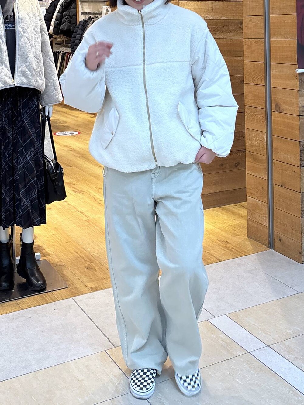 ホワイト系のブルゾン、ベージュ系のデニムパンツ、グレー系のスウェットを着用したレディースの秋コーディネートの5枚目の写真