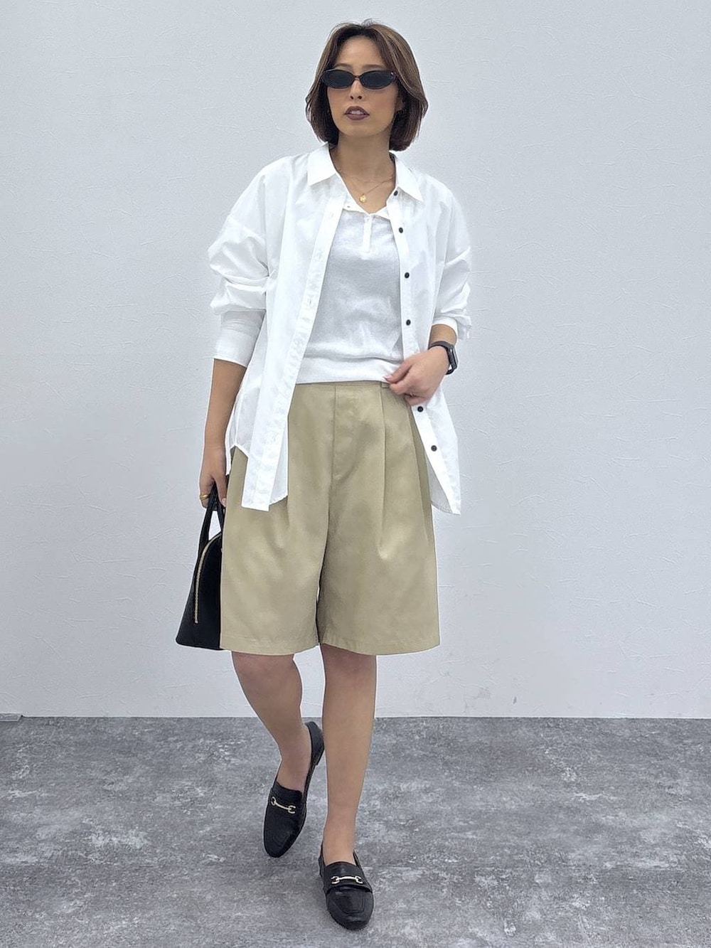 ブラック系のローファー、ブラック系のショルダーバッグ、ホワイト系のシャツ/ブラウスを着用したレディースの春コーディネートの2枚目の写真