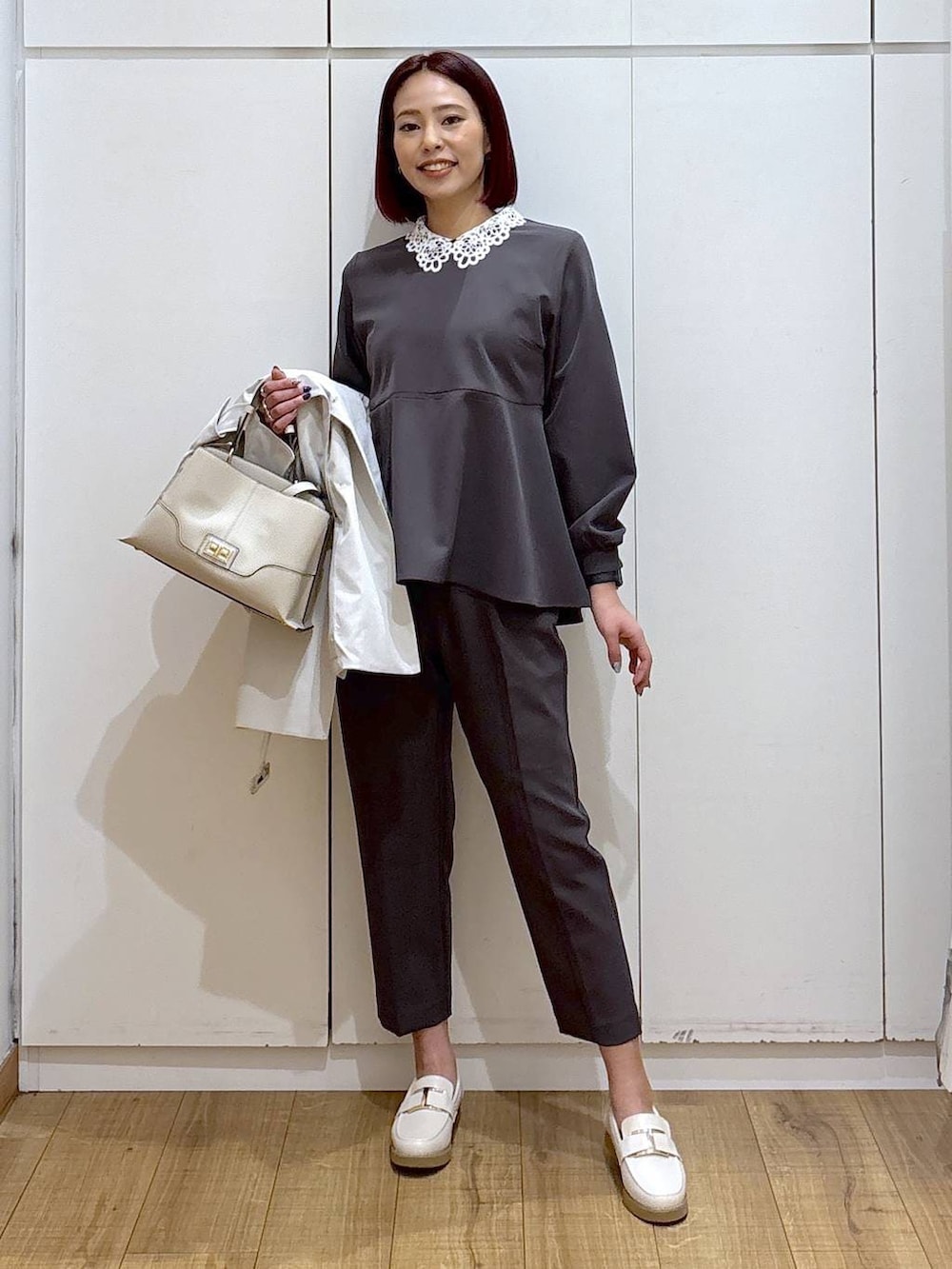 ホワイト系のローファー、グレー系のセットアップ、ベージュ系のショルダーバッグを着用したレディースの春コーディネートの2枚目の写真
