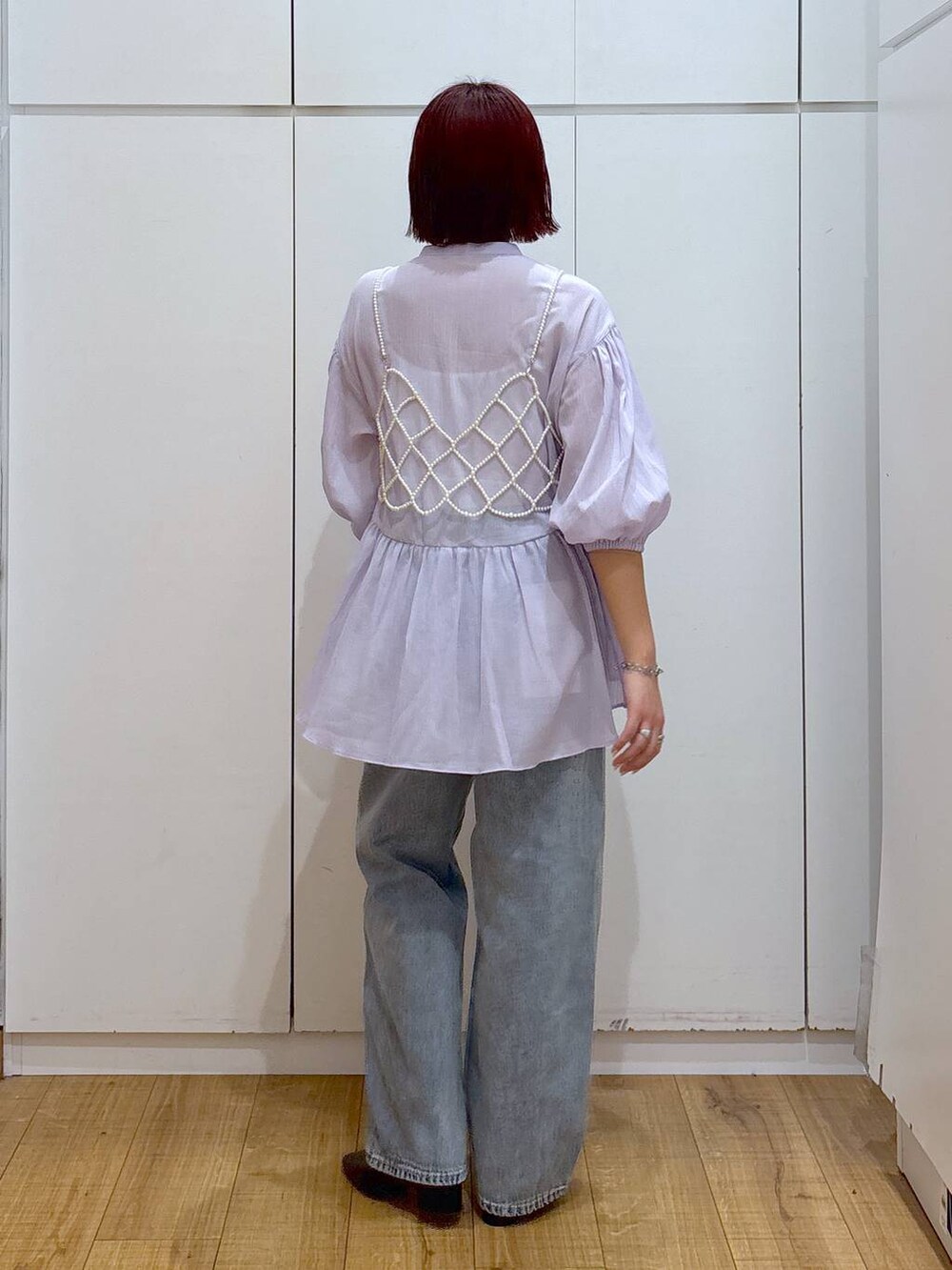 ホワイト系のベスト、ブルー系のデニムパンツ、ベージュ系のトレンチコートを着用したレディースの春コーディネートの8枚目の写真