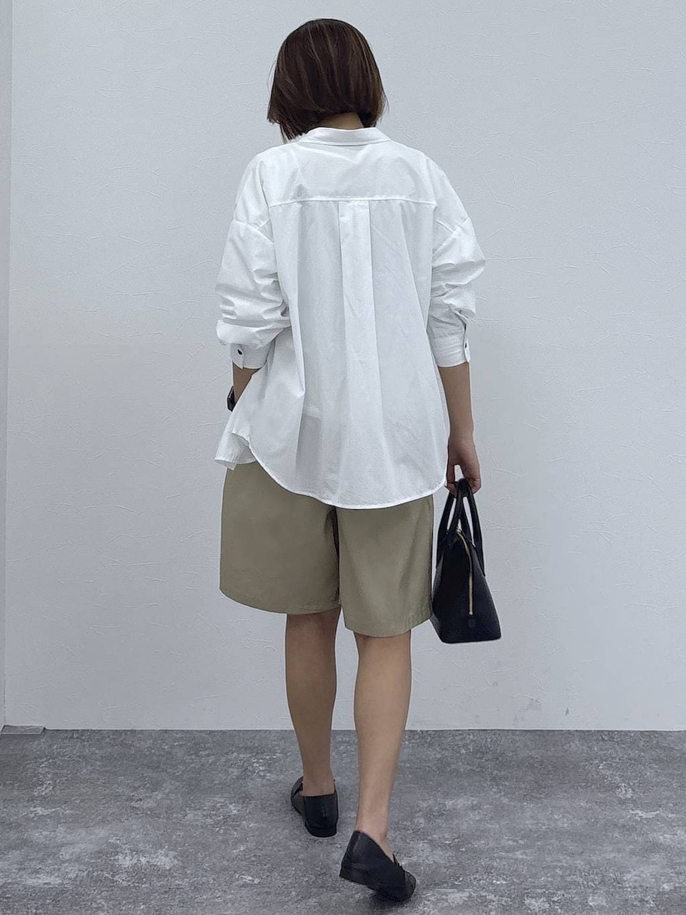 ブラック系のローファー、ブラック系のショルダーバッグ、ホワイト系のシャツ/ブラウスを着用したレディースの春コーディネートの5枚目の写真