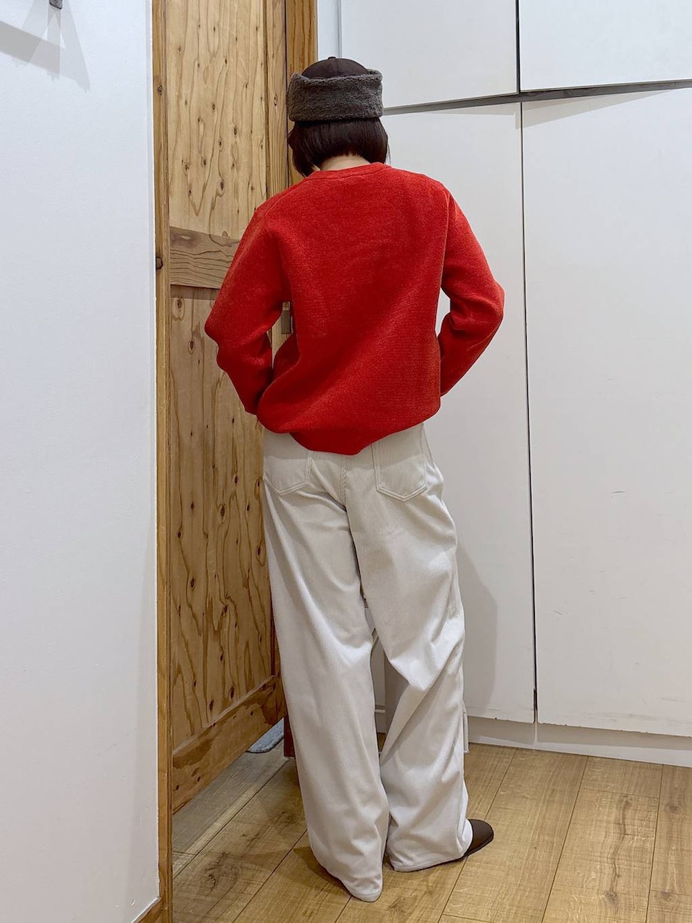 グレー系のその他パンツ、ブラウン系のブーツ、レッド系のニット/セーターを着用したレディースの冬コーディネートの6枚目の写真