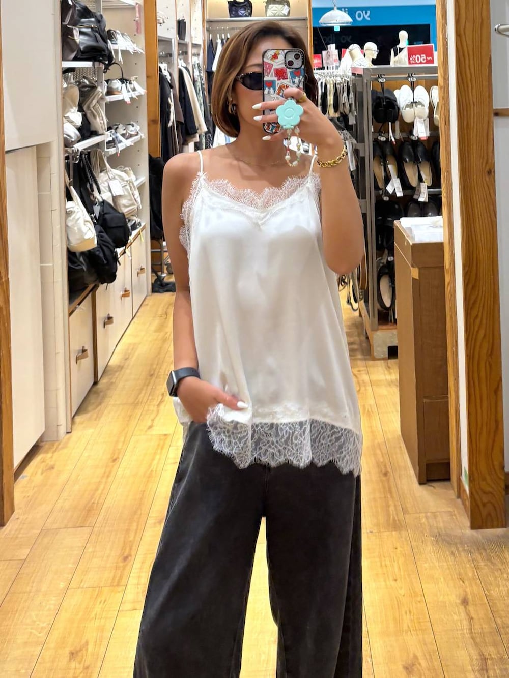 ブラック系のデニムパンツ、ホワイト系のキャミソールを着用したレディースの夏コーディネートの3枚目の写真