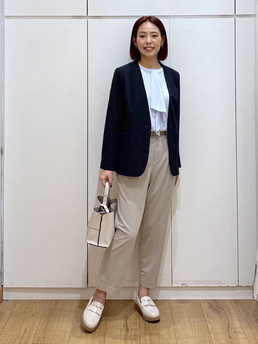 ホワイト系のローファー、ベージュ系のスラックス、ブルー系のシャツ/ブラウスを着用したレディースの春コーディネートの2枚目の写真