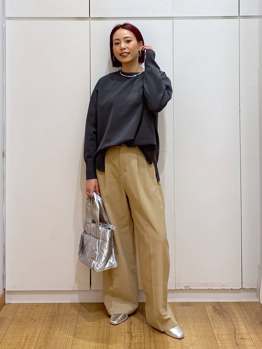 シルバー系のパンプス、グレー系のニット/セーター、シルバー系のトートバッグを着用したレディースの春コーディネートの2枚目の写真
