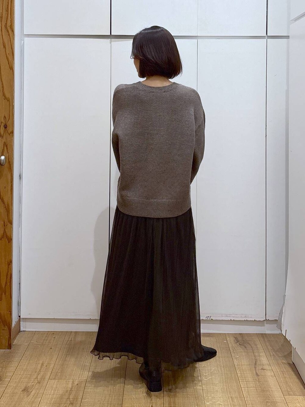 ベージュ系のショルダーバッグ、ブラウン系のワンピース、ブラック系のブーツを着用したレディースの秋コーディネートの3枚目の写真