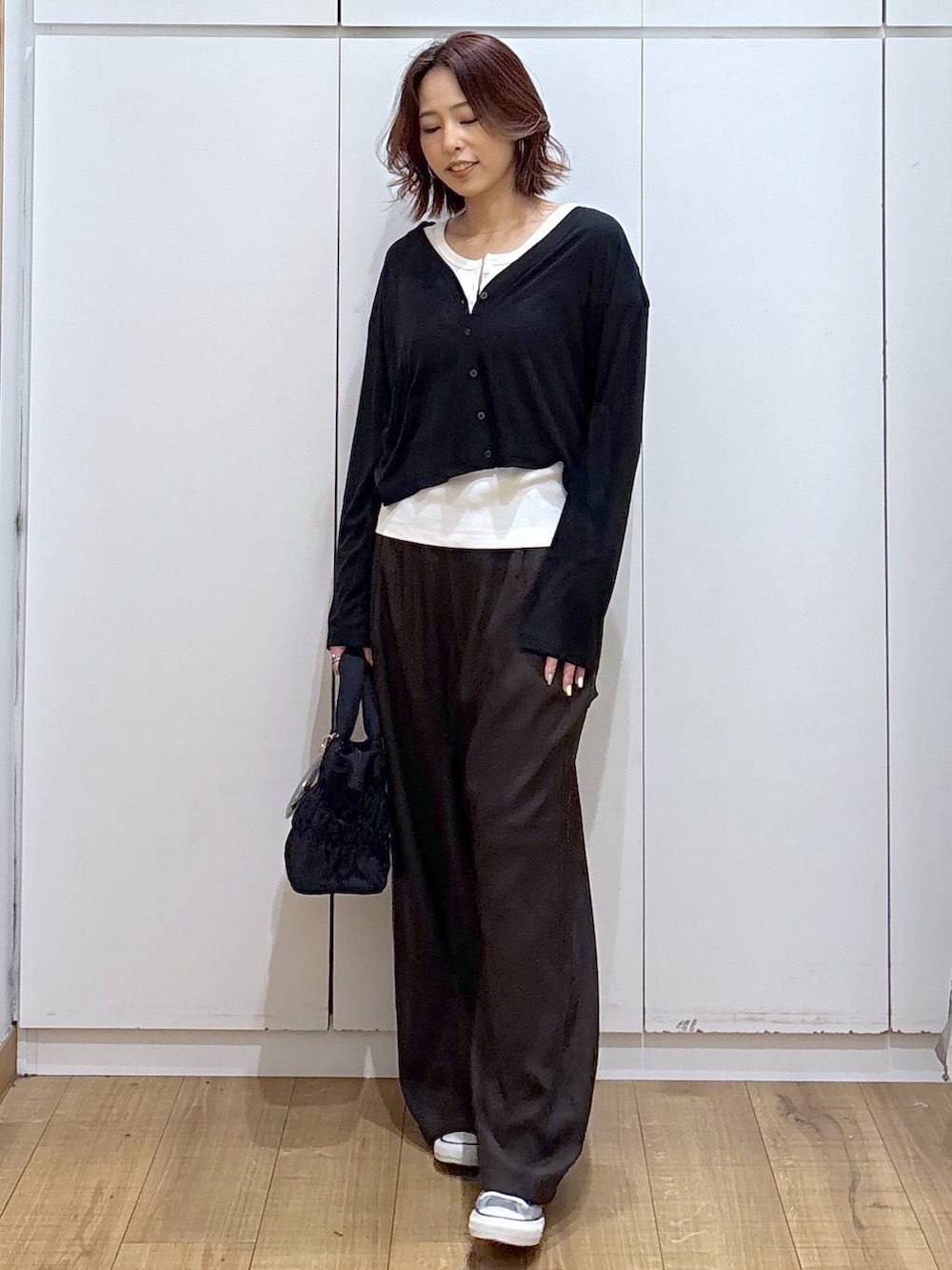 ブラウン系のその他パンツ、ホワイト系のタンクトップ、ブラック系のカーディガン/ボレロを着用したレディースの春コーディネートの6枚目の写真