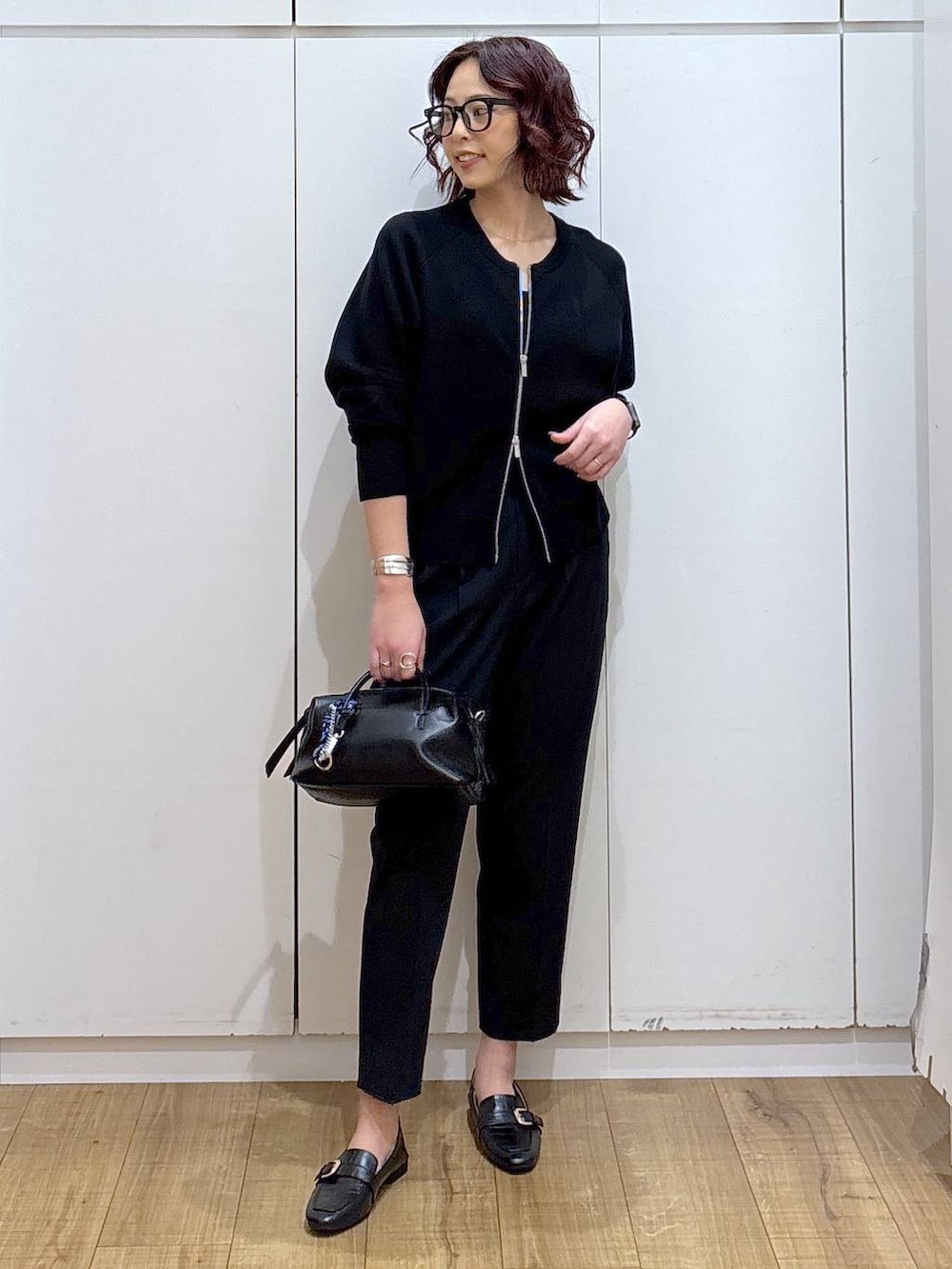 ブラック系のローファー、ブルー系のスラックス、ブラック系のカーディガン/ボレロを着用したレディースの春コーディネートの3枚目の写真