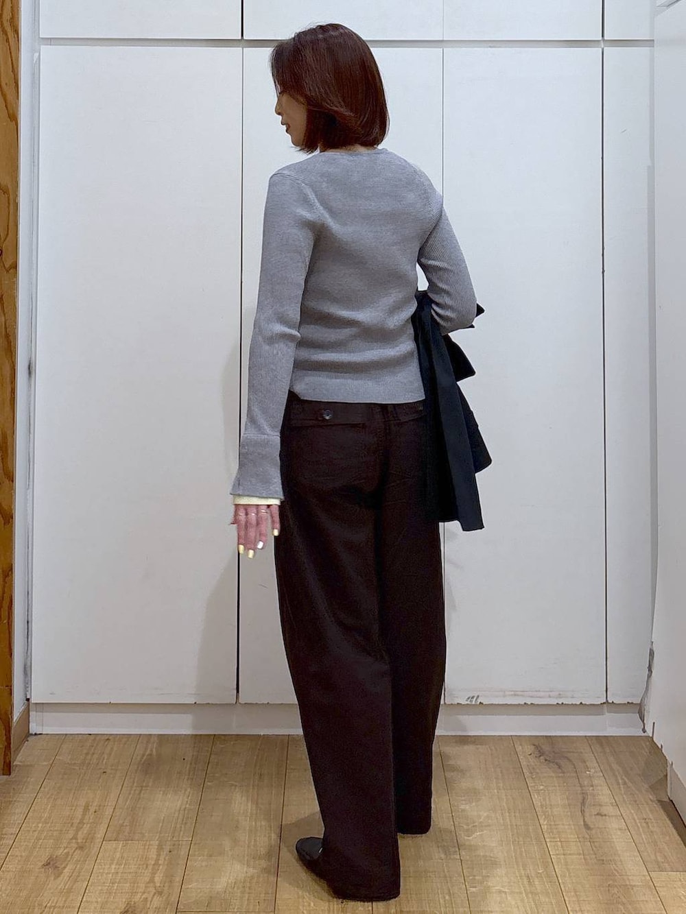 ブラック系のローファー、ブルー系のトレンチコート、グレー系のニット/セーターを着用したレディースの春コーディネートの6枚目の写真