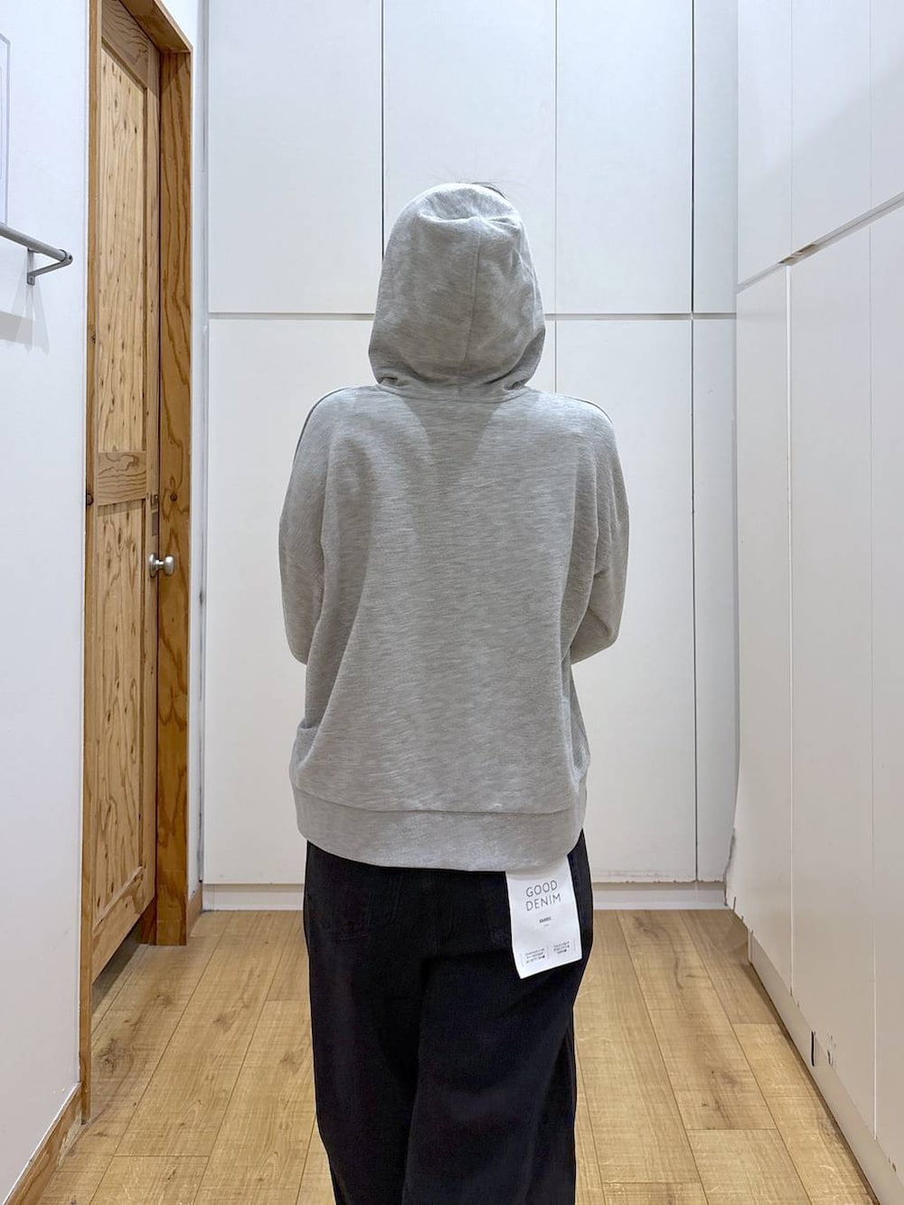 ブラック系のスニーカー、ブラック系のデニムパンツ、グレー系のパーカーを着用したレディースの冬コーディネートの5枚目の写真