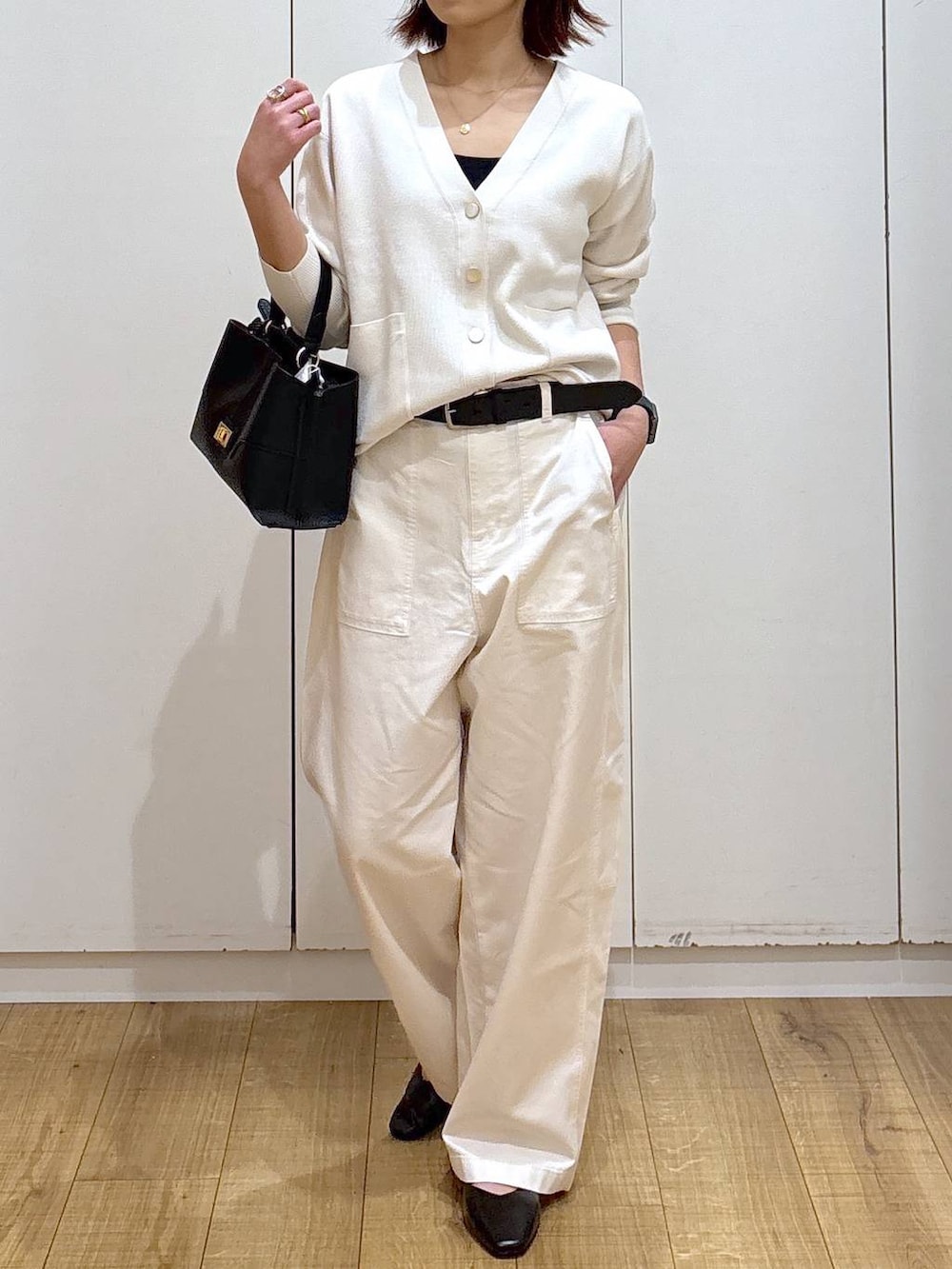 ブラック系のパンプス、ベージュ系のカーディガン/ボレロ、ブラック系のショルダーバッグを着用したレディースの春コーディネートの3枚目の写真