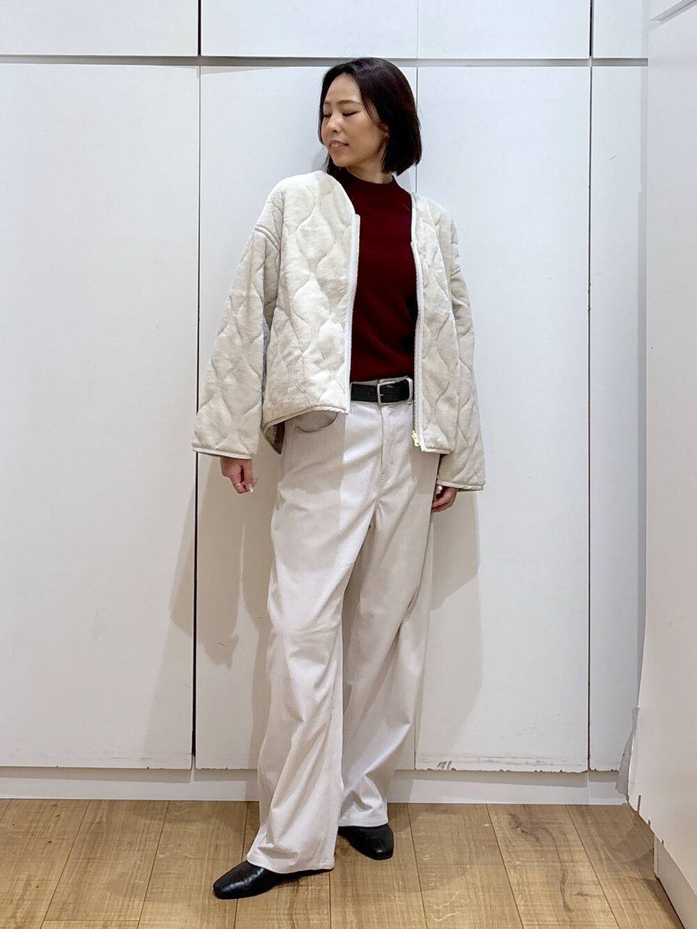 ベージュ系のブルゾン、レッド系のニット/セーター、グレー系のその他パンツを着用したレディースの秋コーディネートの3枚目の写真