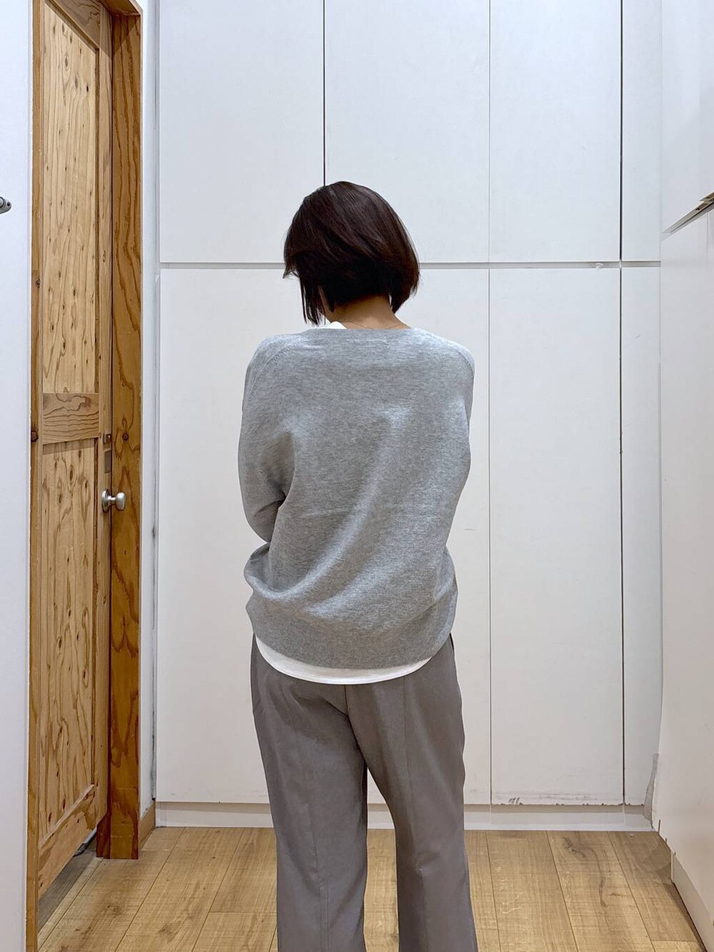 ブラウン系のチェスターコート、グレー系のその他パンツ、ホワイト系のTシャツ/カットソーを着用したレディースの秋コーディネートの6枚目の写真