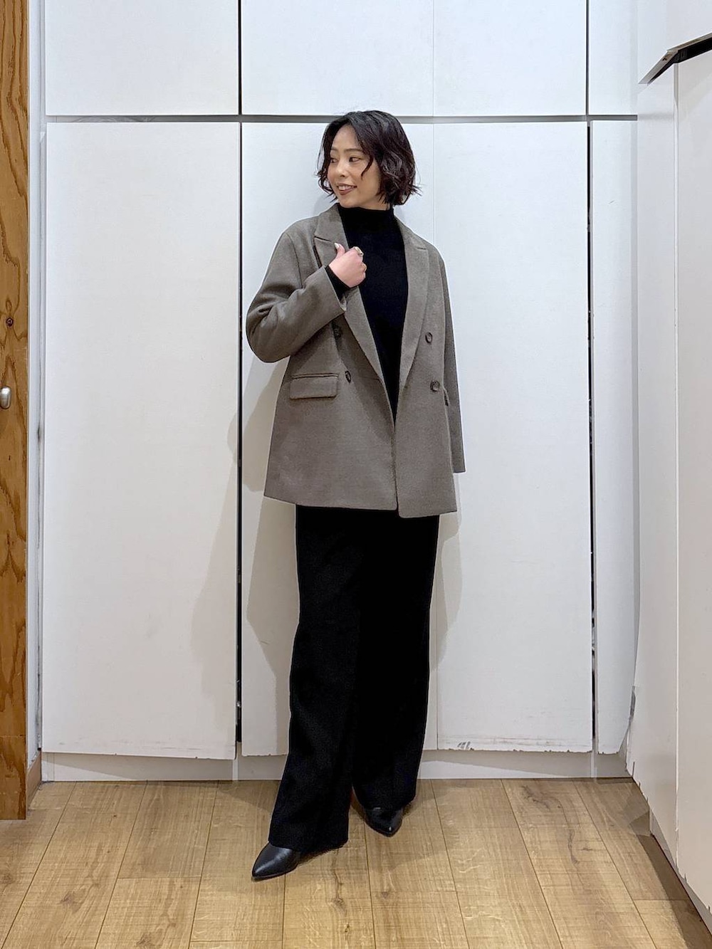 ブラック系のその他パンツ、ブラック系のニット/セーター、ブラウン系のテーラードジャケットを着用したレディースの冬コーディネートの2枚目の写真