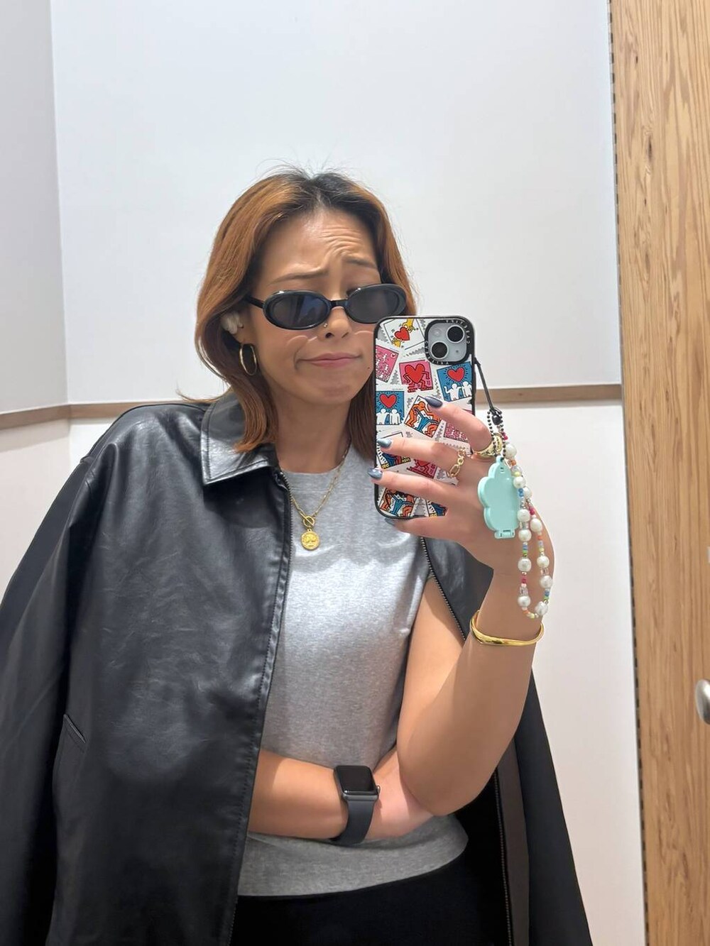 ブラック系のスカート、ブラック系のブルゾン、ゴールド系のバングル/リストバンドを着用したレディースの秋コーディネートの3枚目の写真