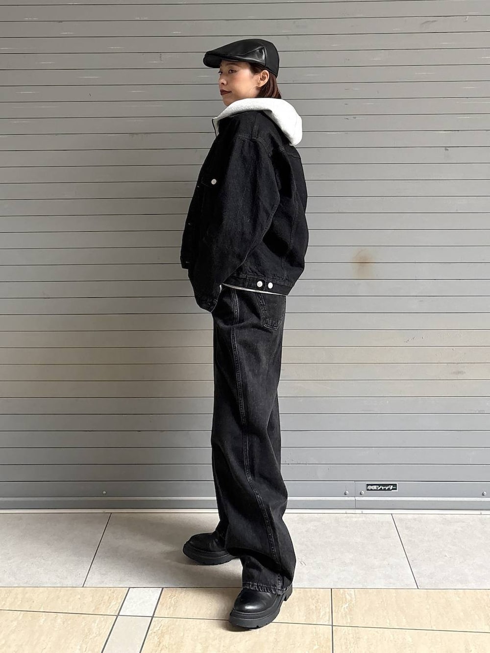 ブラック系のデニムパンツ、ブラック系のデニムジャケット、グレー系のパーカーを着用したレディースの冬コーディネートの3枚目の写真