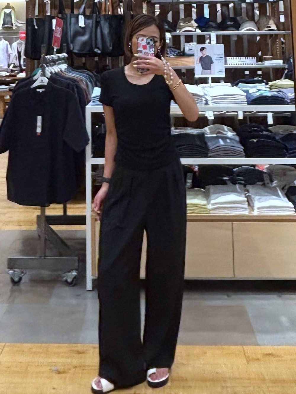 ブラック系のその他パンツ、ホワイト系のサンダルを着用したレディースの夏コーディネートの2枚目の写真