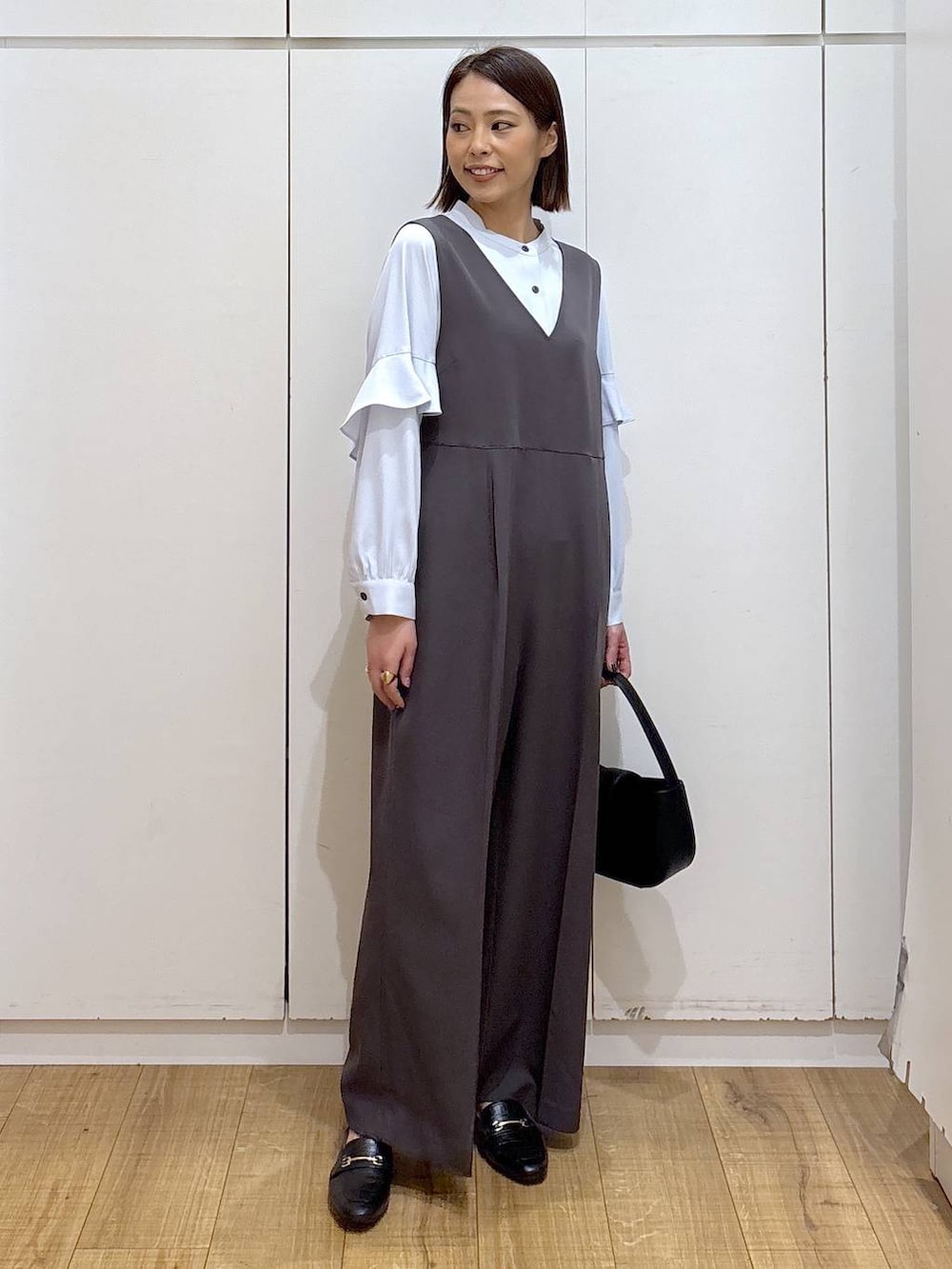 ブラック系のローファー、グレー系のセットアップ、ブラック系のハンドバッグを着用したレディースの冬コーディネートの4枚目の写真