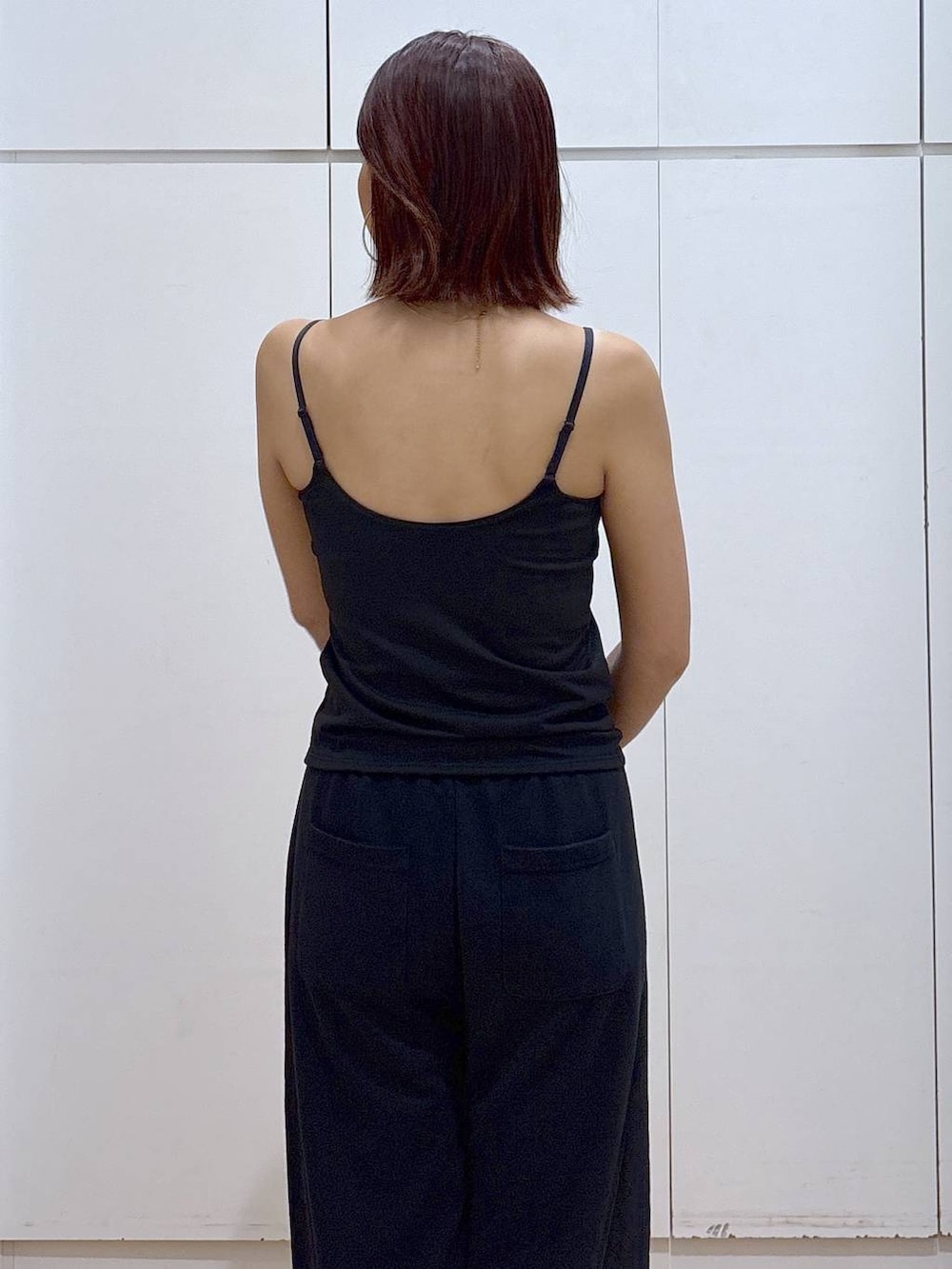 ブラック系のキャミソール、ブラック系のスウェットパンツ、ゴールド系のネックレスを着用したレディースの春コーディネートの6枚目の写真