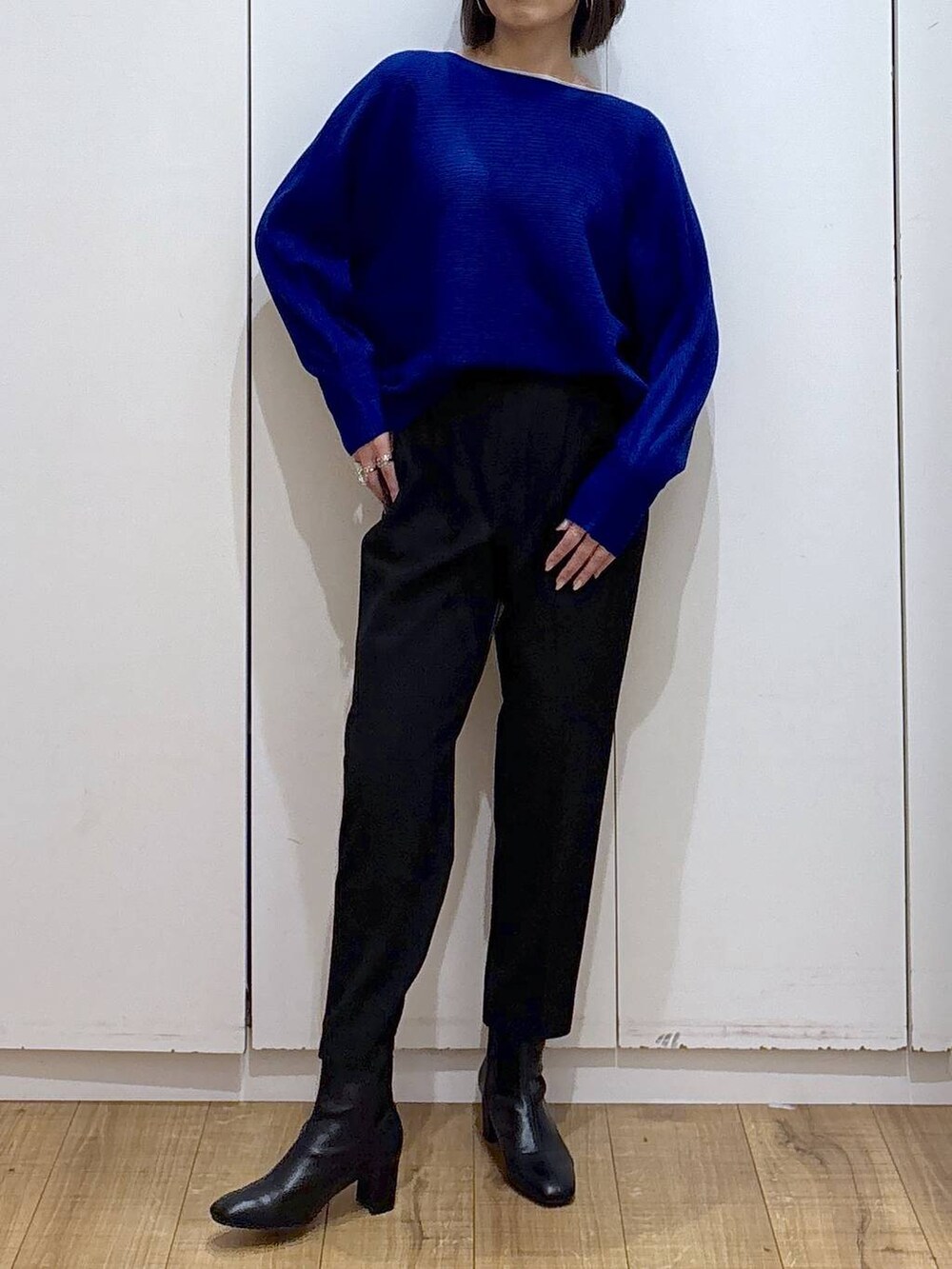 ブラック系のその他パンツ、ブルー系のニット/セーター、ブラック系のブーツを着用したレディースの秋コーディネートの4枚目の写真