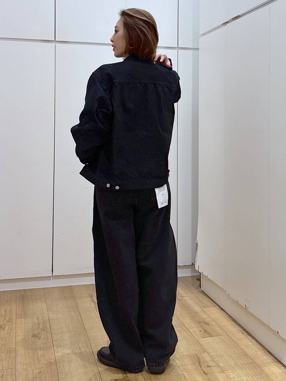 ブラック系のデニムパンツ、ブラック系のデニムジャケット、ホワイト系のキャミソールを着用したレディースの春コーディネートの5枚目の写真