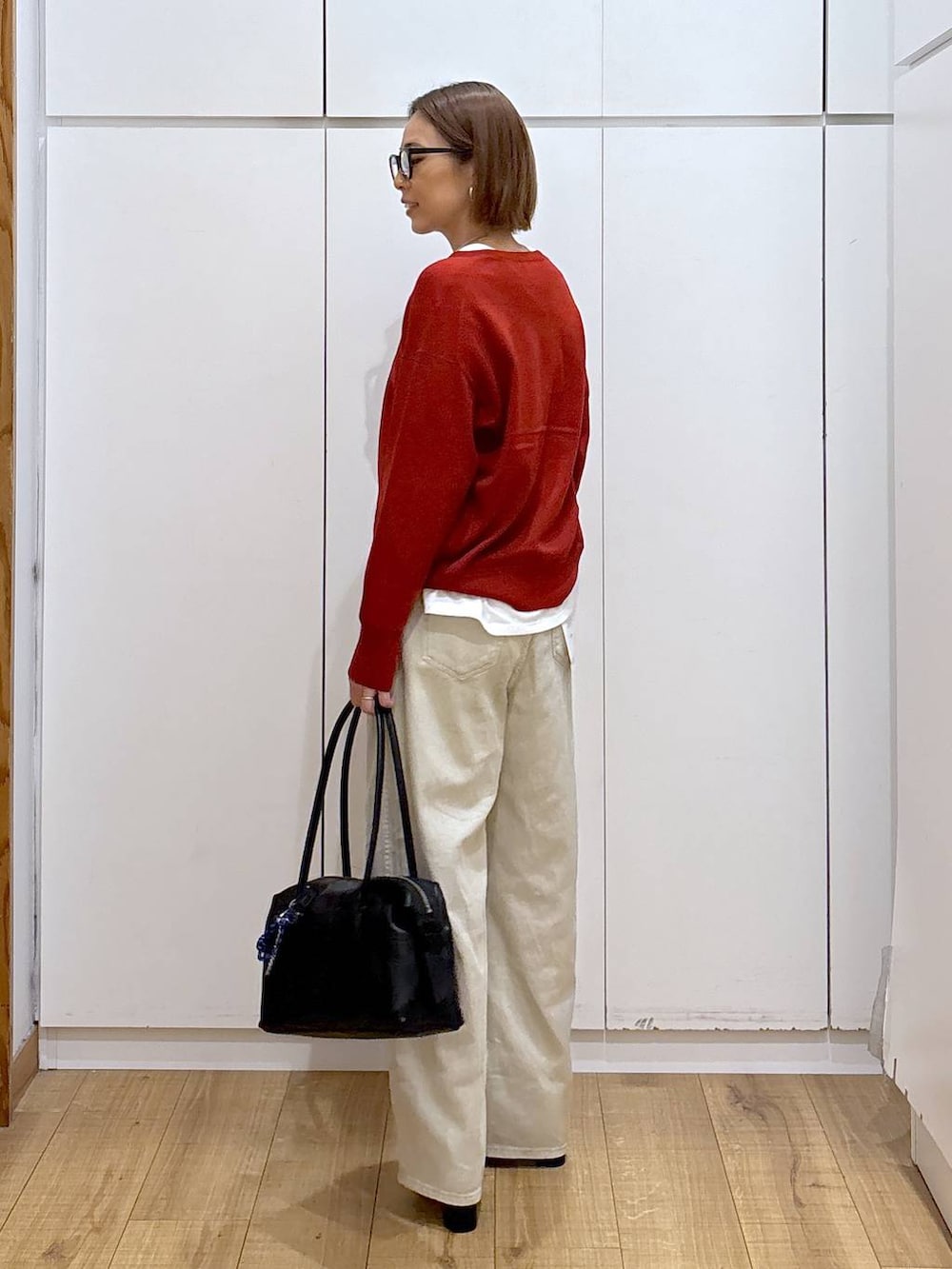 ブラック系のボストンバッグ、ベージュ系のデニムパンツ、ホワイト系のTシャツ/カットソーを着用したレディースの秋コーディネートの4枚目の写真