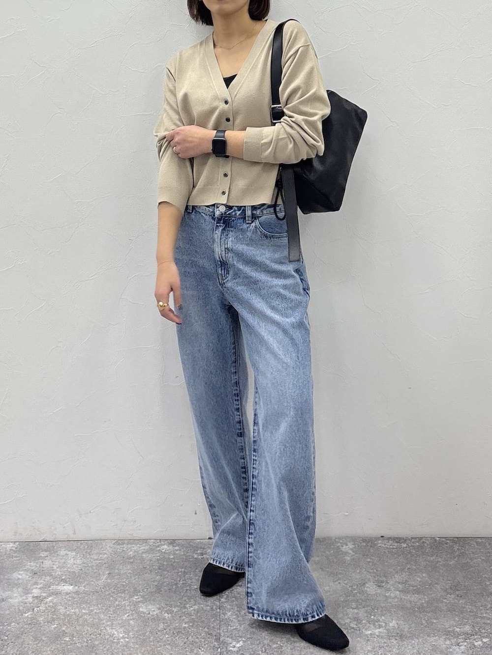 ブラック系のショルダーバッグ、ゴールド系のピアス（両耳用）、ゴールド系のリングを着用したレディースの冬コーディネートの3枚目の写真