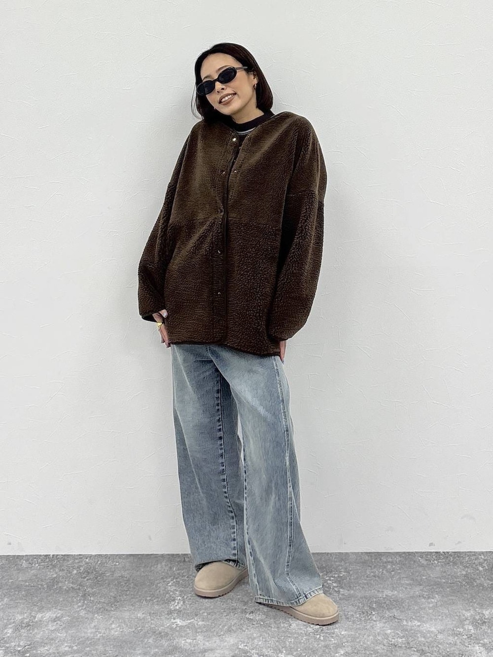 ホワイト系のニット/セーター、ブルー系のデニムパンツ、ブラウン系のノーカラージャケットを着用したレディースの冬コーディネートの5枚目の写真