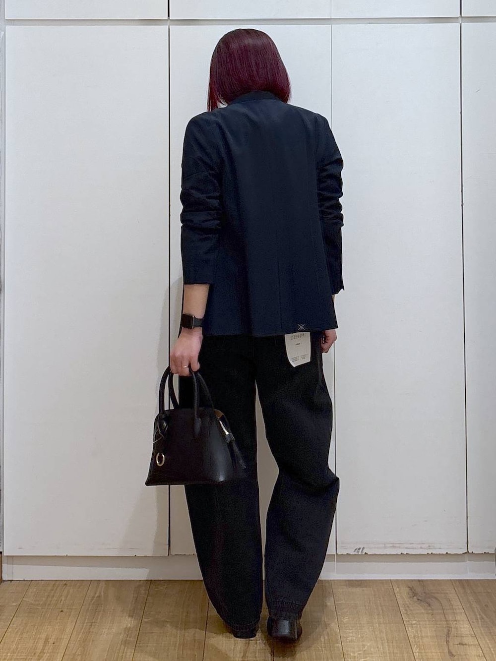 ブラック系のショルダーバッグ、ブラック系のブーツ、ブルー系のノーカラージャケットを着用したレディースの春コーディネートの8枚目の写真