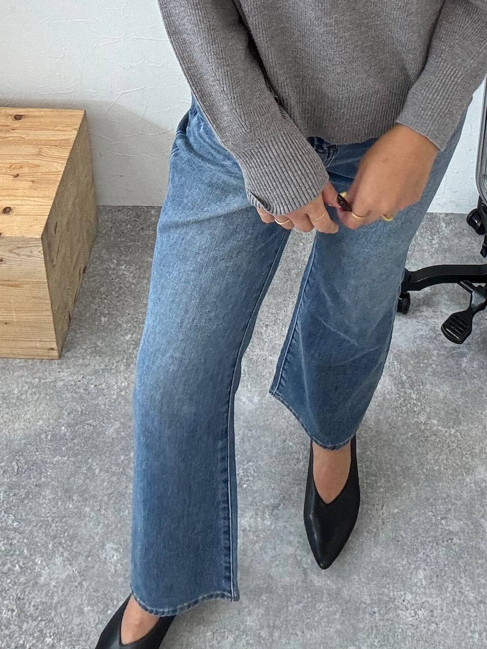 ブラック系のボストンバッグ、ブルー系のデニムパンツ、ブラック系のパンプスを着用したレディースの秋コーディネートの3枚目の写真