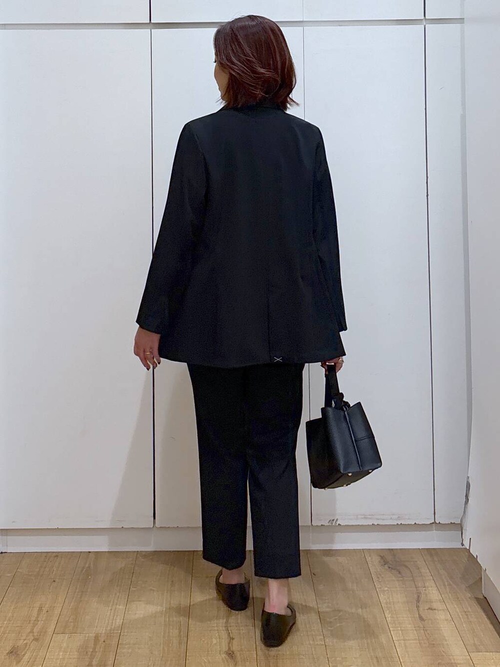 ブラック系のパンプス、ブラック系のスラックス、ブルー系のシャツ/ブラウスを着用したレディースの春コーディネートの5枚目の写真
