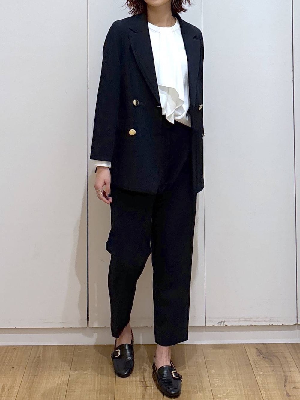 ブラック系のローファー、ブルー系のスラックス、ホワイト系のシャツ/ブラウスを着用したレディースの春コーディネートの4枚目の写真