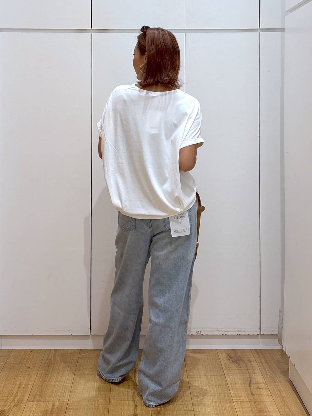 ブルー系のデニムパンツ、ホワイト系のショルダーバッグ、ホワイト系のTシャツ/カットソーを着用したレディースの夏コーディネートの4枚目の写真