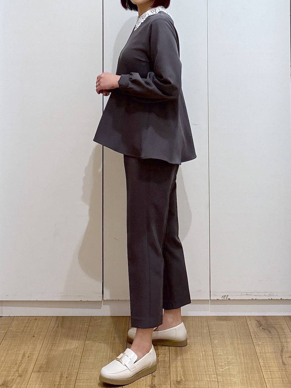 ホワイト系のローファー、グレー系のセットアップ、ベージュ系のショルダーバッグを着用したレディースの春コーディネートの5枚目の写真